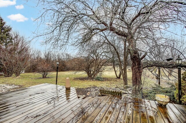 wooden terrace featuring a lawn