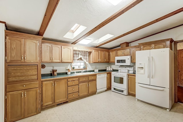 kitchen with lofted ceiling with skylight, a sink, dark countertops, white appliances, and light floors