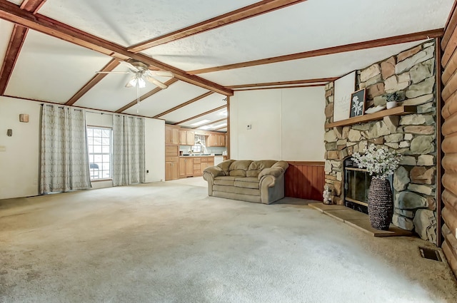 unfurnished living room featuring visible vents, vaulted ceiling with beams, light carpet, a fireplace, and a ceiling fan