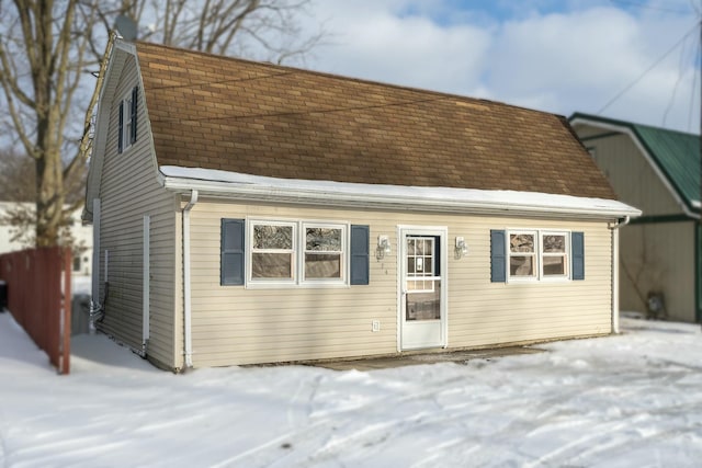 view of front facade with roof with shingles and a gambrel roof