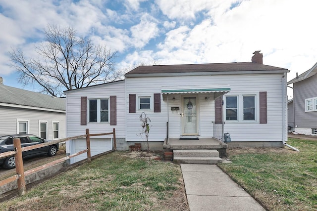 bungalow-style house with a front yard and a chimney