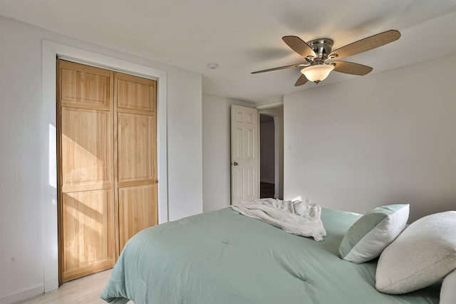 bedroom with a ceiling fan, light wood-type flooring, and a closet