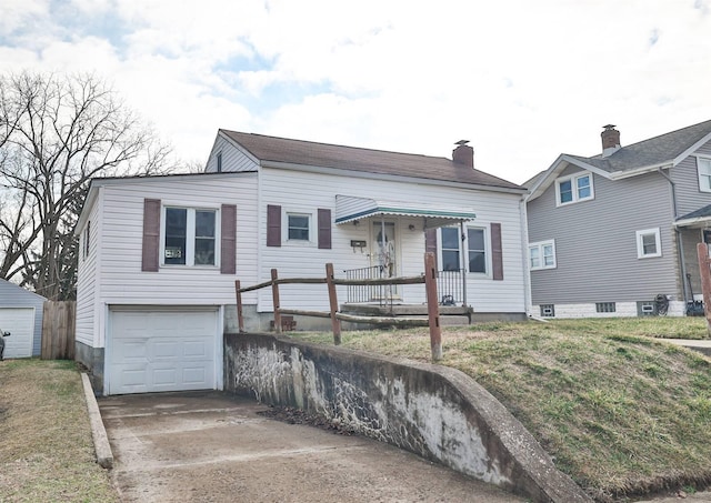 view of front of house featuring a garage, driveway, a chimney, and a front yard