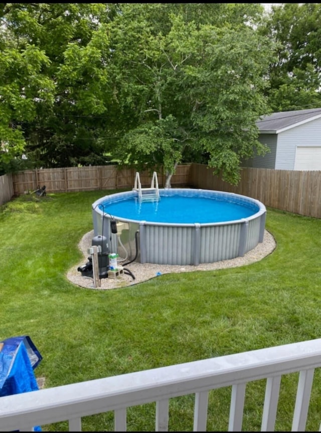 view of swimming pool featuring a lawn, a fenced backyard, and a fenced in pool