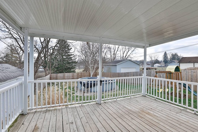 wooden terrace with a fenced backyard, a trampoline, and a playground