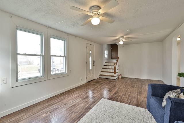 foyer with plenty of natural light, a textured ceiling, stairway, and wood finished floors