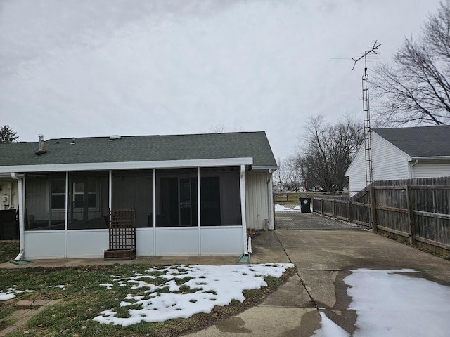 view of snowy exterior with a sunroom