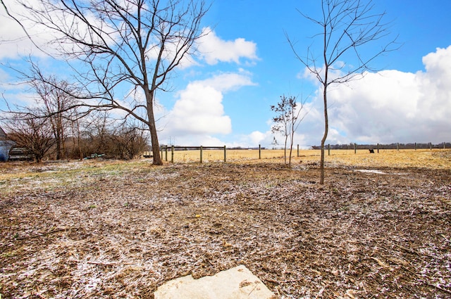 view of yard with a rural view and fence