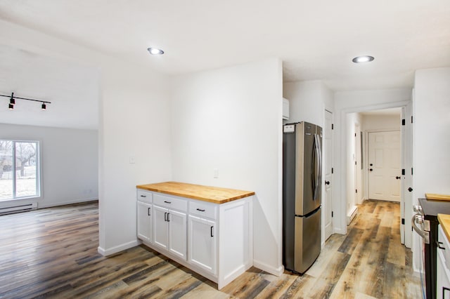 kitchen featuring white cabinetry, baseboards, light wood-style floors, wooden counters, and appliances with stainless steel finishes