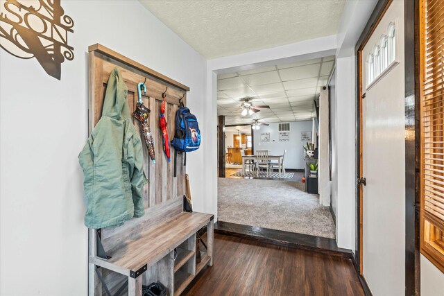 mudroom featuring ceiling fan, a drop ceiling, a textured ceiling, and dark wood finished floors