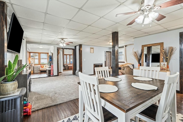 dining space with a paneled ceiling, a ceiling fan, and wood finished floors