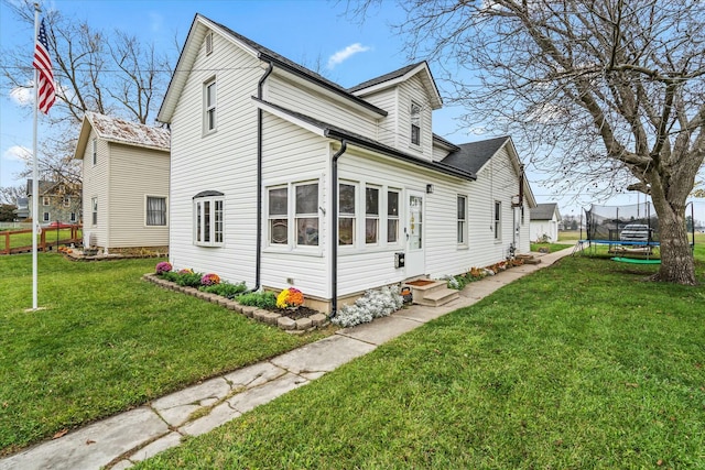 view of home's exterior featuring a yard, entry steps, and a trampoline