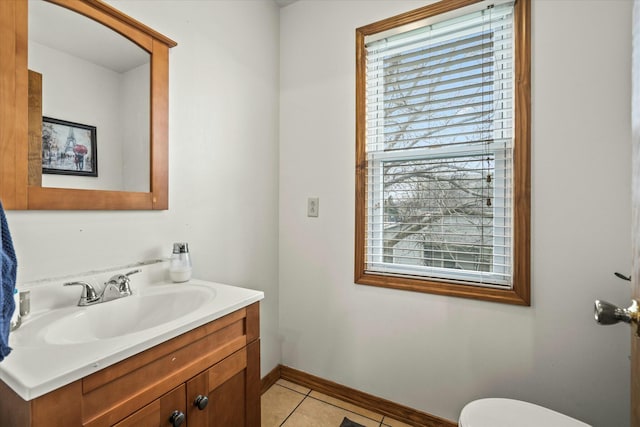 bathroom with baseboards, toilet, vanity, and tile patterned flooring