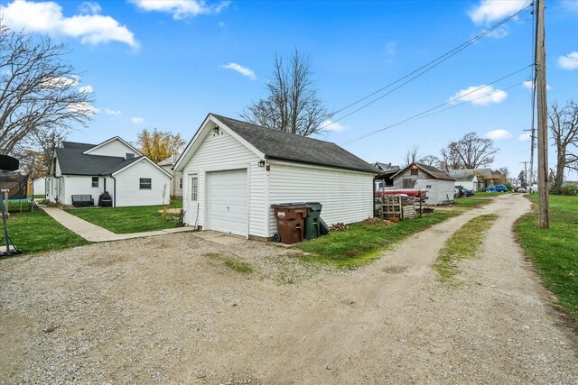 detached garage featuring a trampoline and driveway