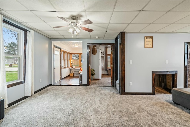 carpeted spare room with baseboards, a paneled ceiling, and ceiling fan