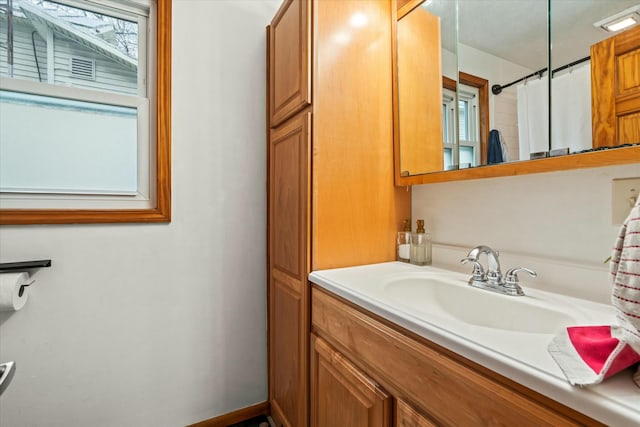 full bath featuring vanity and baseboards