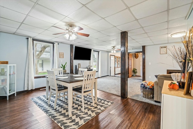 dining space with baseboards, a paneled ceiling, dark wood-style flooring, and ceiling fan