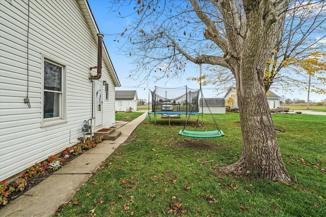 view of yard with entry steps and a trampoline