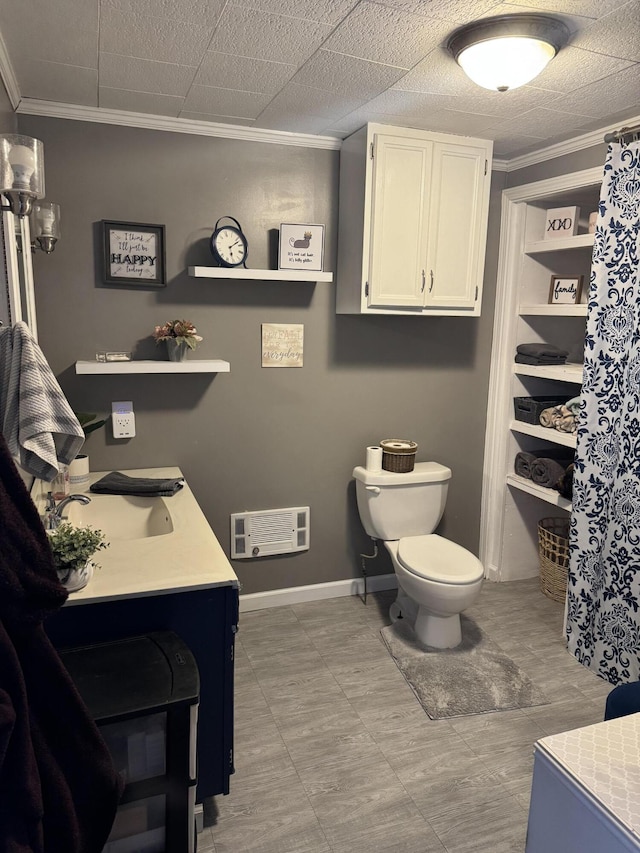 full bathroom with baseboards, vanity, toilet, and crown molding