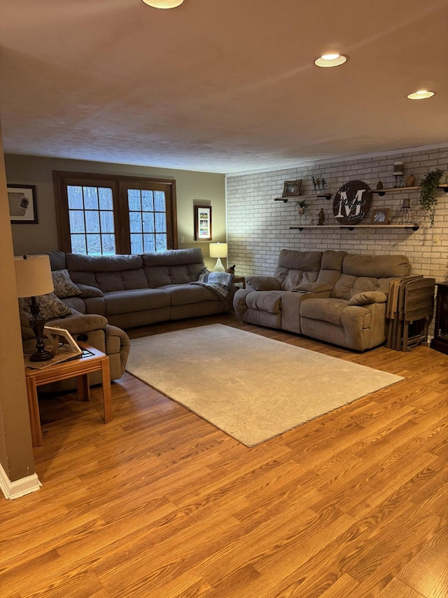 living room featuring brick wall, recessed lighting, and light wood-style floors