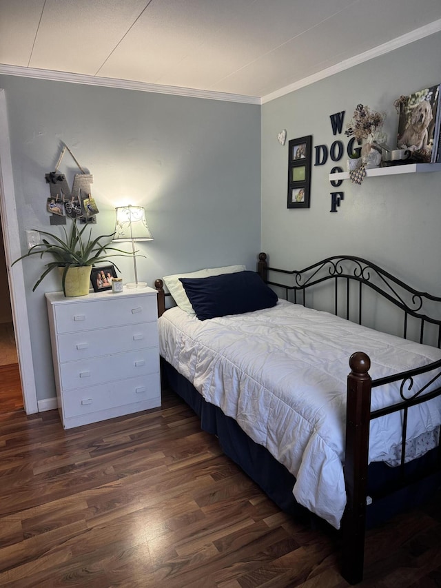 bedroom featuring ornamental molding and wood finished floors