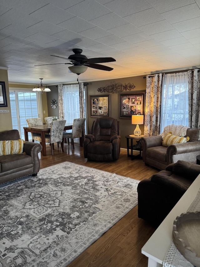 living area with ceiling fan, ornamental molding, and wood finished floors