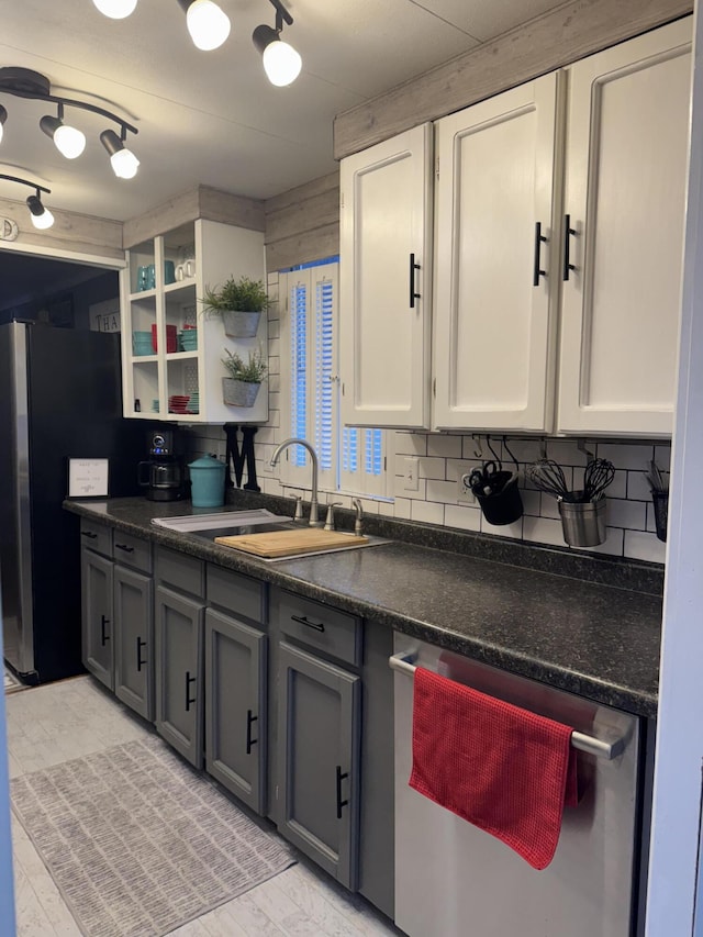 kitchen with open shelves, stainless steel appliances, dark countertops, backsplash, and a sink