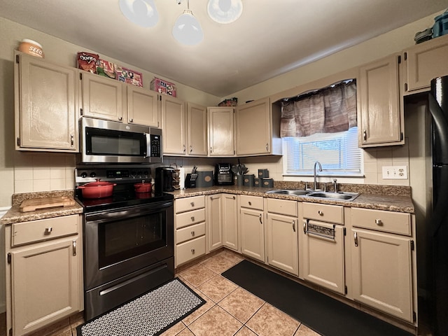 kitchen with light tile patterned flooring, appliances with stainless steel finishes, sink, and decorative backsplash