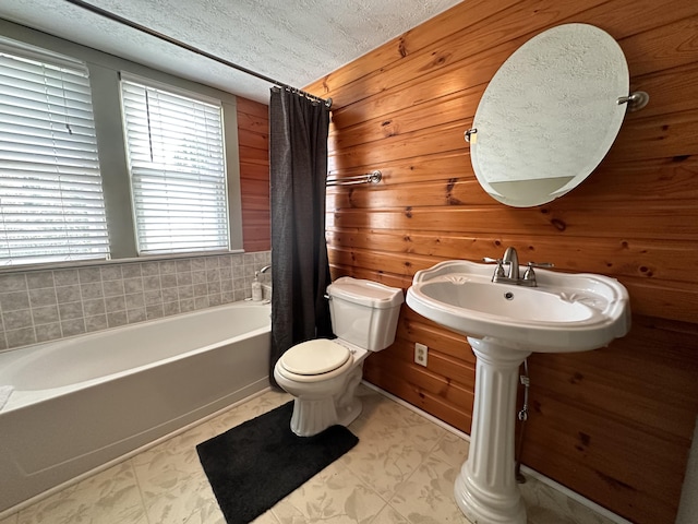 bathroom with shower / tub combo with curtain, toilet, a textured ceiling, and wood walls