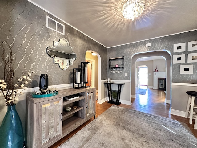 interior space with hardwood / wood-style flooring, ornamental molding, and a chandelier