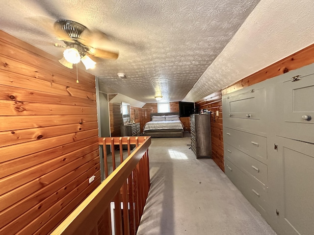 hallway with a textured ceiling and wood walls