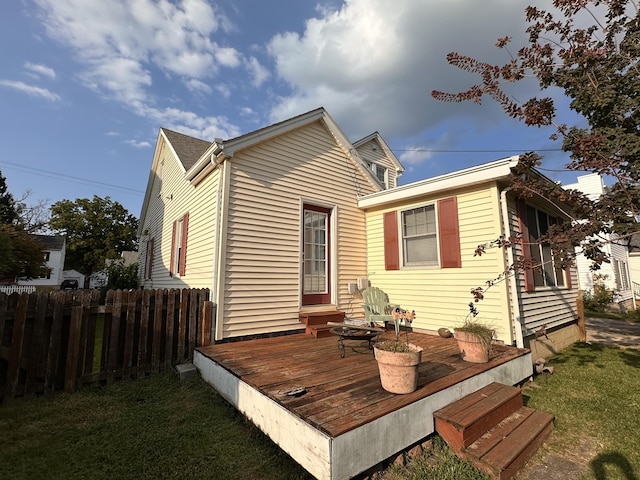 back of property with a wooden deck and a yard