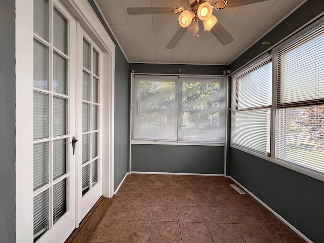 unfurnished sunroom with a healthy amount of sunlight and ceiling fan