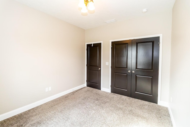 unfurnished bedroom featuring baseboards, carpet flooring, visible vents, and a closet