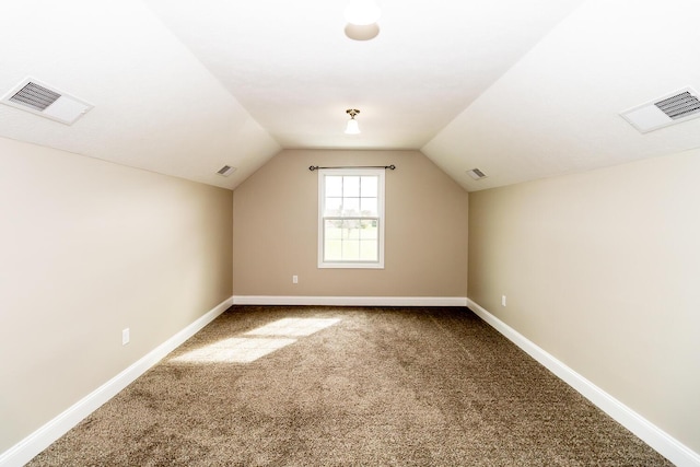 additional living space featuring baseboards, visible vents, lofted ceiling, and carpet flooring
