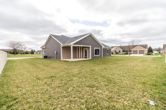 rear view of house with cooling unit, a patio, and a yard