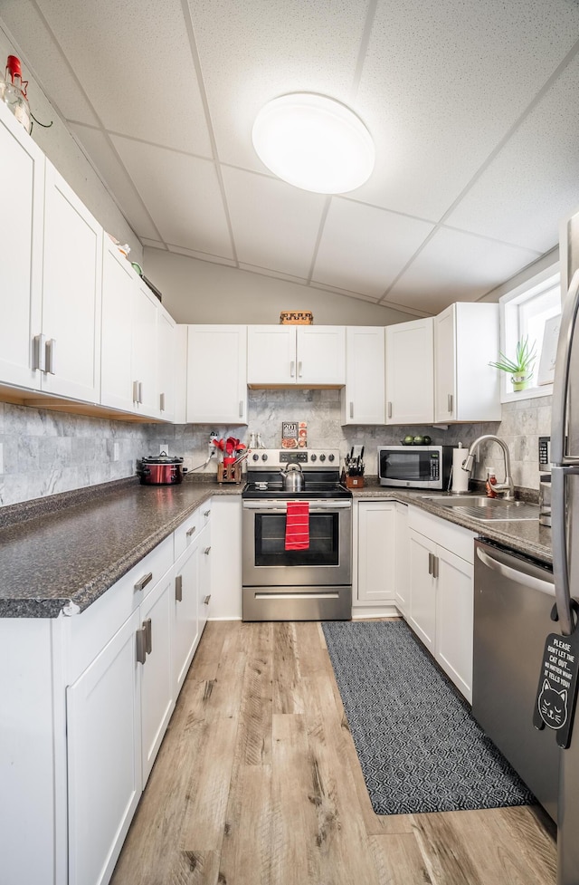 kitchen featuring a sink, a drop ceiling, backsplash, and stainless steel appliances