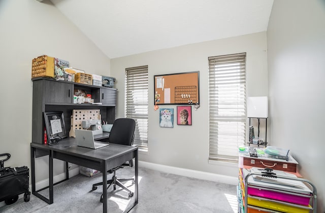 office area featuring lofted ceiling, light colored carpet, and baseboards