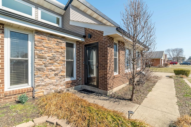 view of exterior entry with brick siding