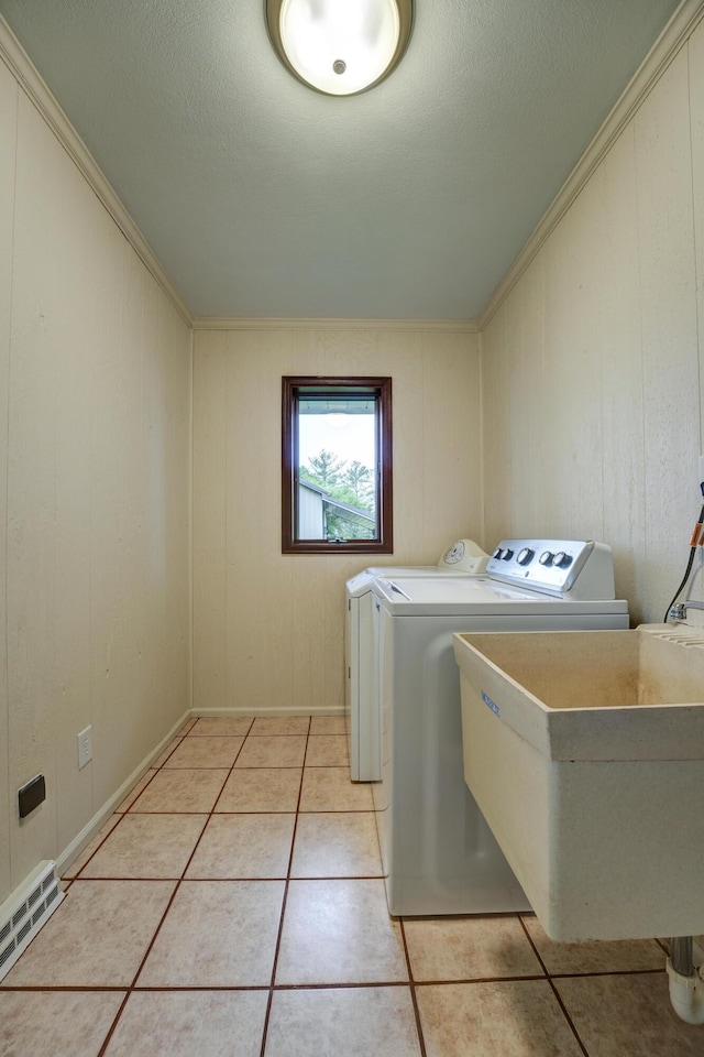 5341 Riffle Rd, Ansonia, OH 45303 - washroom featuring washer and clothes dryer, light tile patterned flooring, and crown molding
