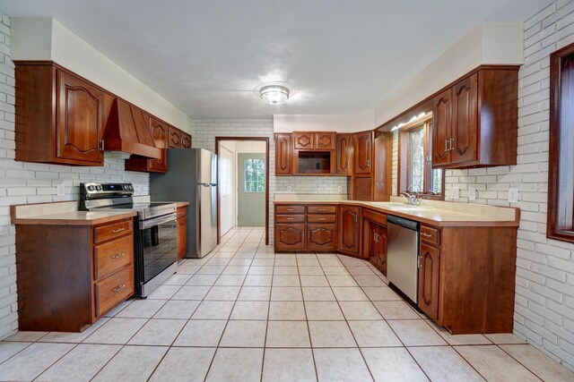 5341 Riffle Rd, Ansonia, OH 45303 - kitchen featuring stainless steel appliances, premium range hood, light countertops, a sink, and brick wall