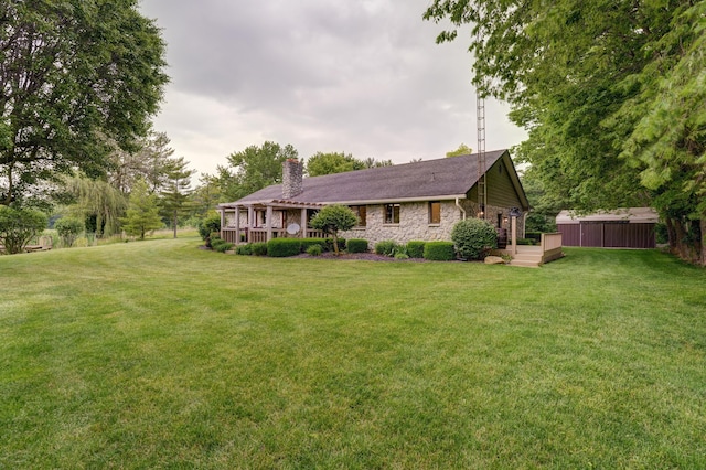 5341 Riffle Rd, Ansonia, OH 45303 - view of front facade featuring a chimney, a wooden deck, a front yard, and stone siding