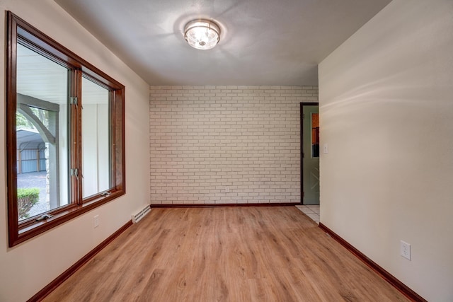 5341 Riffle Rd, Ansonia, OH 45303 - unfurnished room with brick wall, plenty of natural light, light wood finished floors, and baseboards