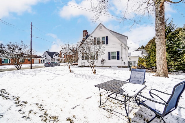 view of snow covered rear of property