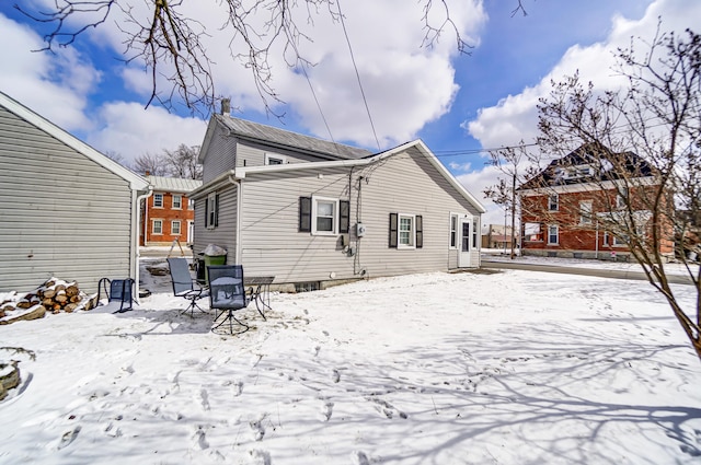 view of snow covered rear of property