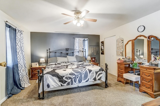 carpeted bedroom featuring multiple windows and ceiling fan