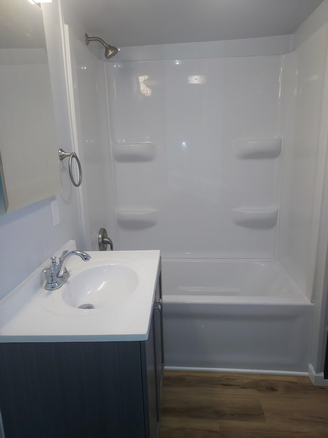 bathroom with vanity, wood finished floors, and tub / shower combination