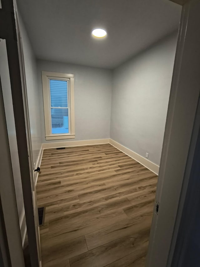 unfurnished room with recessed lighting, visible vents, baseboards, and dark wood-style floors