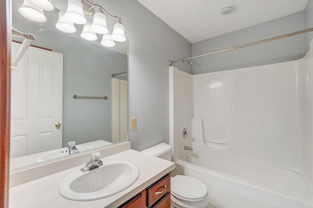 full bath with toilet, a textured ceiling, vanity, and shower / washtub combination
