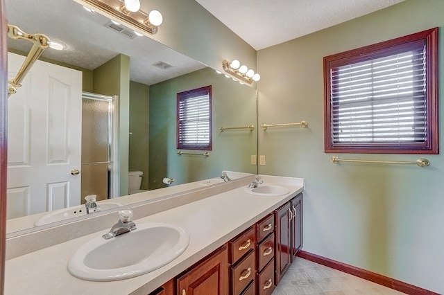 bathroom featuring a sink, visible vents, baseboards, and a shower stall